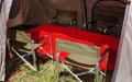 The interior of mess tent with dining chairs and table.